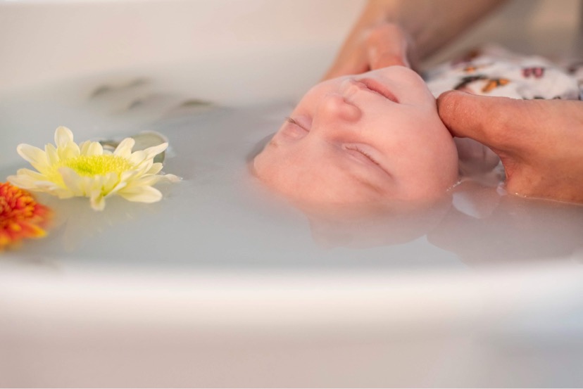 bébé en pleine séance de bain enveloppé
